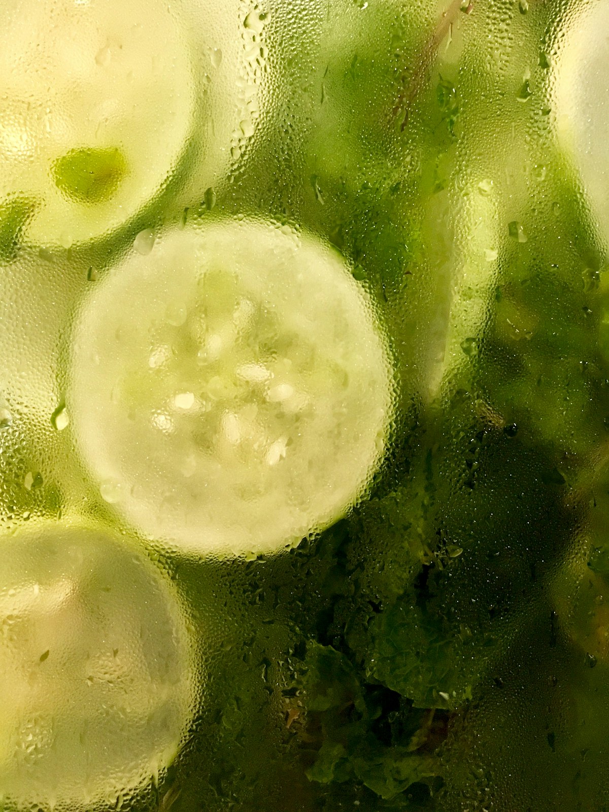 Cucumber slices pressed against cold glass