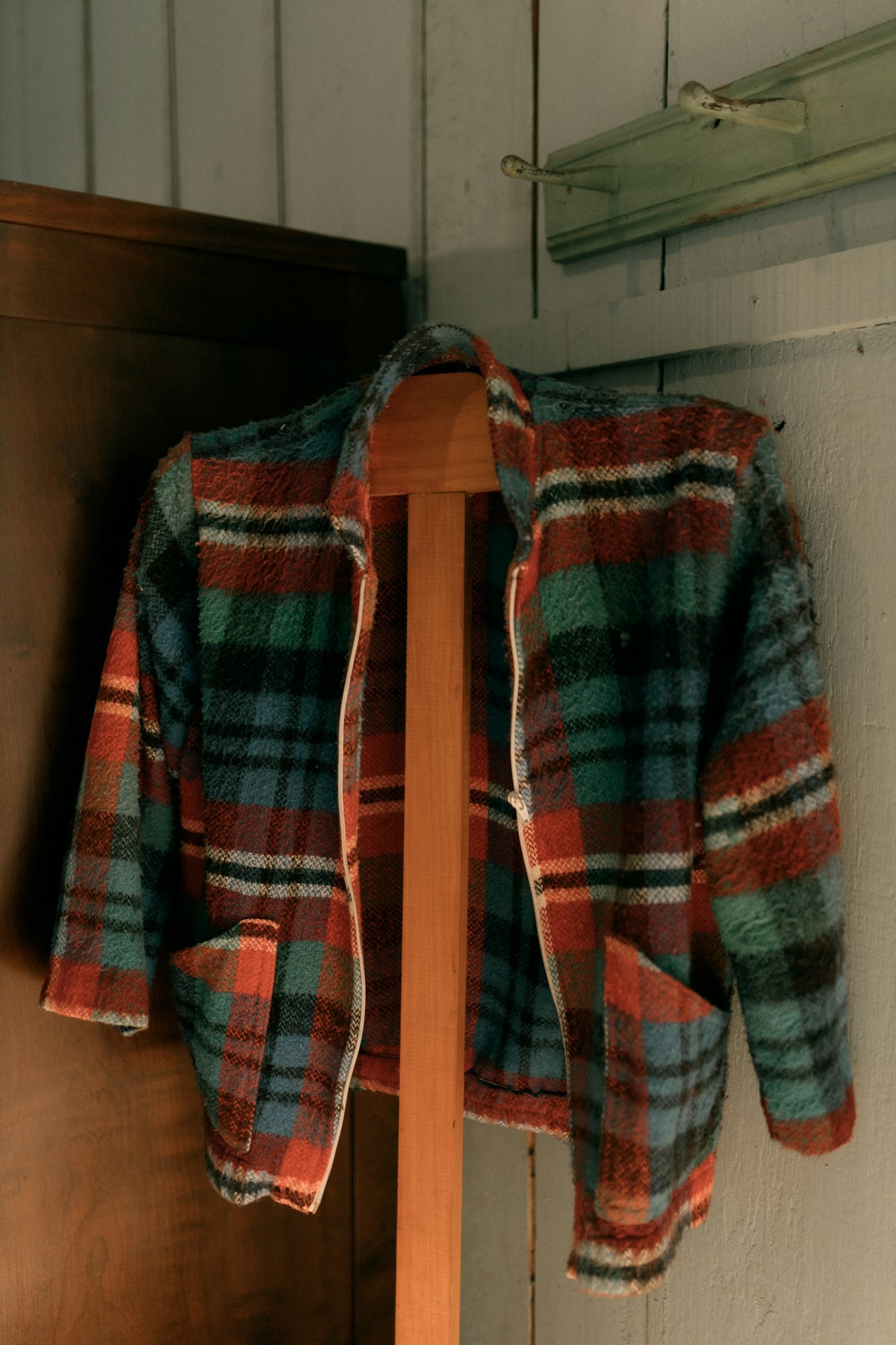 Plaid wool overshirt hanging on a wooden rack